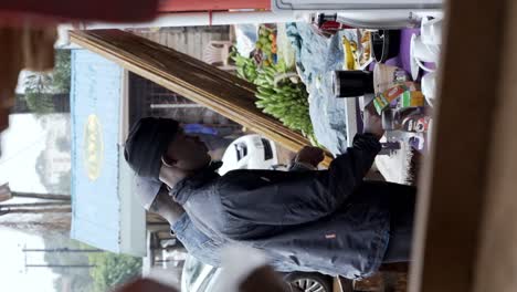 People-Enjoying-Breakfast-at-a-Market-in-Tanzania,-East-Africa---Vertical-Shot