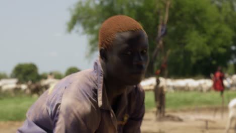 4K-footage-of-a-man-playing-a-local-musical-instrument-in-the-cattle-camp-in-the-village-of-the-Mundari-tribe-based-in-Juba,-Terekeka-county