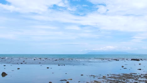 International-flight-airplane-flying-over-ocean-with-a-glimpse-of-tropical-Atauro-Island-flying-into-the-remote-tourism-destination-of-Dili,-Timor-Leste-in-Southeast-Asia