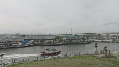 An-aerial-view-captures-the-Port-of-Houston-Fire-Department's-Firestorm-70-emergency-response-boat-passing-by-Kemah-Boardwalk-and-entering-Clear-Lake-in-Kemah,-Seabrook,-Texas