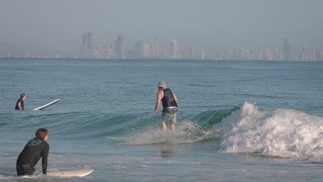 Primer-Plano-De-Un-Surfista-En-Una-Tabla-Larga-Disfrutando-De-Pequeñas-Olas-Limpias-En-Un-Día-Tranquilo-En-Snapper-Rocks,-Gold-Coast.