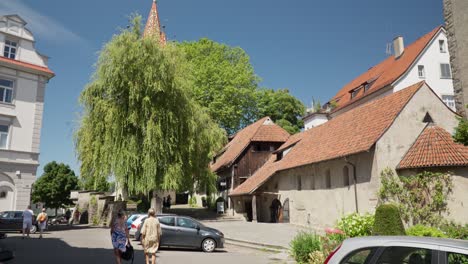 Sunny-day-in-Lindau-with-people-strolling-and-historic-buildings,-clear-sky