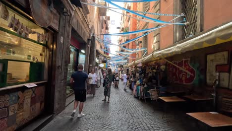 Toma-En-Primera-Persona-De-Caminar-Por-Una-Calle-Estrecha-En-El-Centro-De-La-Ciudad-Con-Tiendas-Y-Cafés-De-Nápoles-En-Italia