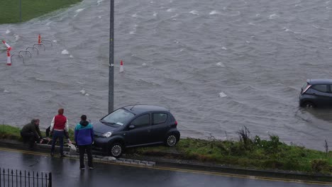 Un-Grupo-De-Vecinos-Consigue-Empujar-El-Coche-Para-Sacarlo-Del-Aparcamiento-Inundado.