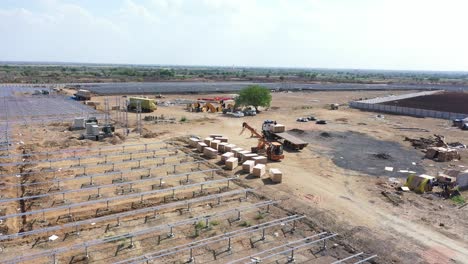 Aerial-drone-view-drum-camera-moving-forward-of-large-truck-unloading-boxes-of-solar