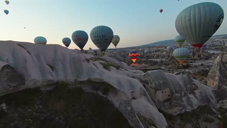 Globos-Aerostáticos-Flotando-Sobre-Chimeneas-De-Hadas-Y-Colinas-Blancas-Al-Amanecer-En-Capadocia,-Turquía.