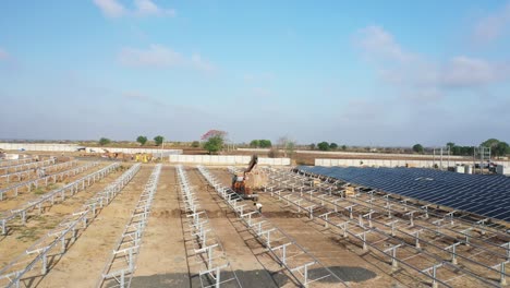 Cámara-De-Teléfono-Con-Vista-Aérea-De-Drones-Moviéndose-Hacia-El-Lado-Donde-Moto-Jcb-Lleva-La-Caja-Del-Panel-Solar