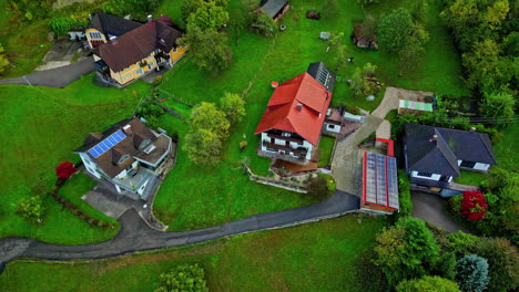 Beautiful-and-colorful-aerial-shot-of-houses-with-high-ceilings-and-solar-panels,-surrounded-by-trees,-roads-and-nature