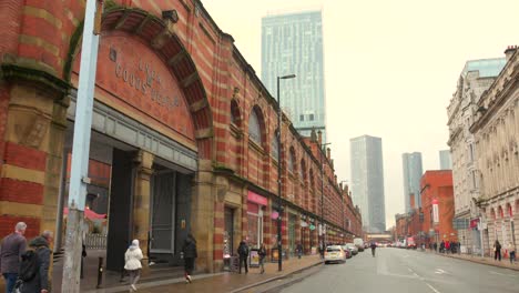 Una-Calle-De-Manchester-Con-Depósitos-De-Mercancías-Y-Rascacielos-Al-Fondo.