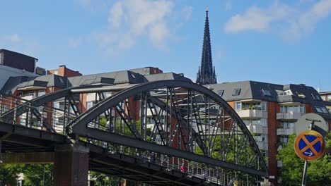 Low-angle-view-of-a-metallic-walkway-bridge-in-Hamburg,-Germany-with-skyscape-at-background