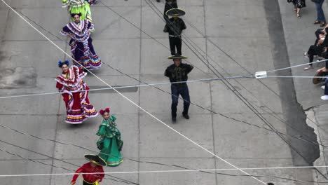 Charro-Demonstrating-Trick-Roping-with-Group-Of-Dancers-and-Musicians-During-The-Mariachi-Festival-Parade-In-Tecalitlan,-Jalisco,-Mexico