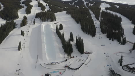 Luftdrohne-Sonnenuntergang-Halfpipe-Copper-Mountain-Colorado-Ikone-Epischer-Pass-Winter-Frühling-Sonnig-Erstes-Licht-Sonnenaufgang-Morgen-Sessellift-Skipisten-Zentrum-Dorf-Langsam-Kreisbewegung