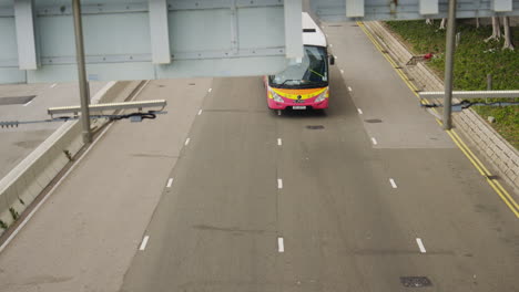 A-perspective-view-of-an-overpass-captures-buses,-trucks-and-cars-driving-on-a-freeway-in-Hong-Kong,-China