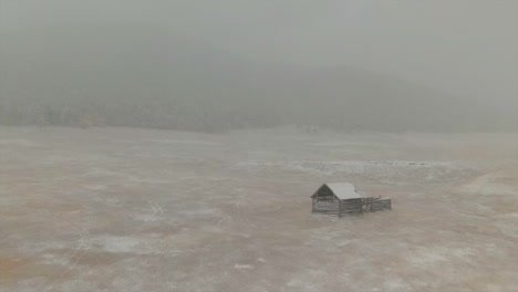 Open-Space-Evergreen-Colorado-first-snow-grassy-field-red-brown-horse-barn-aerial-drone-fall-autumn-winter-blizzard-snowy-Rocky-Mountain-front-range-Denver-historic-town-backward-movement