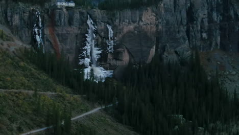 Telluride-Colorado-aerial-drone-Bridal-Veil-Falls-frozen-ice-waterfall-autumn-sunset-cool-shaded-Rocky-Mountains-Silverton-Ouray-Millon-Dollar-Highway-historic-town-scenic-landscape-slow-pan-up