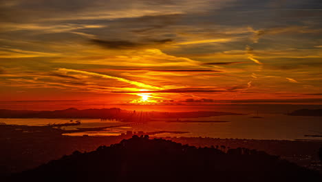 Bahía-De-San-Francisco-Vista-Desde-El-Lado-De-Oakland-Del-Puerto-Durante-Una-Puesta-De-Sol-Dorada---Paisaje-Nublado-De-Lapso-De-Tiempo