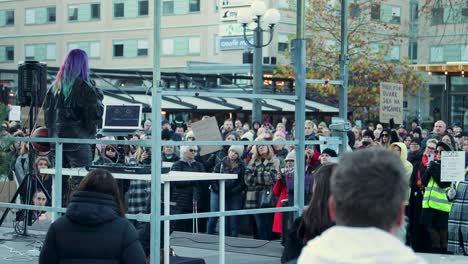 Activist-Linnea-Claeson-speaking-at-rally,-large-crowd-gathered-in-urban-setting,-daytime,-activism-event