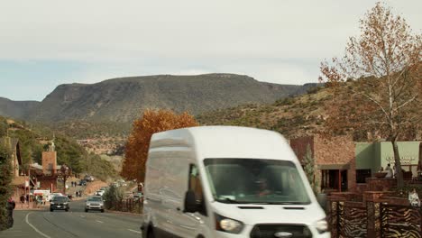 Downtown-Sedona,-Arizona-with-pedestrians-vehicles-driving-with-video-tilting-down