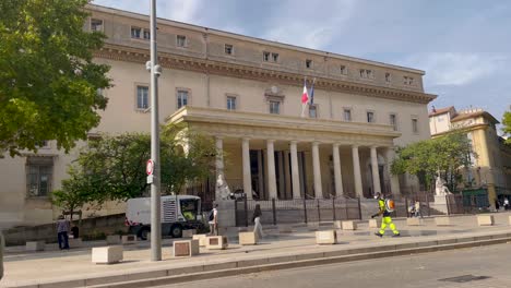 Hombre-Caminando-Por-Un-Palacio-De-Justicia-Neoclásico-En-Aix-en-provence,-Día-Soleado,-Vista-A-La-Calle