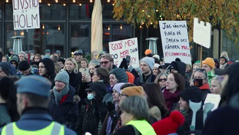 Crowd-of-diverse-people-at-women's-rights-rally-in-Stockholm,-holding-signs,-daytime