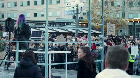 Crowd-gathered-at-women's-rights-rally-in-Stockholm-with-speaker-Linnea-Claeson-and-protest-signs