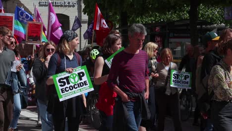 People-with-signs-and-LGBTQ-flags-at-climate-protest-march-in-Sweden