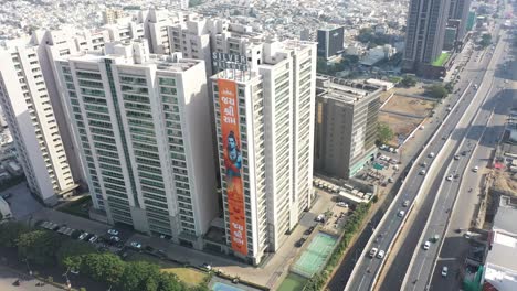 Rajkot-aerial-drone-view-where-photo-flowers-are-visible-around-and-many-big-complexes-and-silver-height-big-buildings-are-visible-around