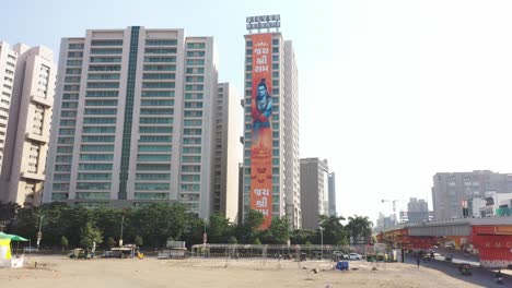 Rajkot-aerial-drone-view-camera-moving-towards-side-where-different-big-buildings-are-visible-and-silver-height-big-Jai-Shri-Ram-banner-is-visible