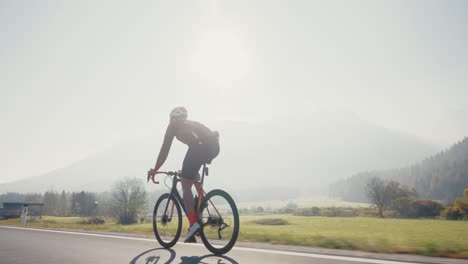 Männlicher-Radfahrer-Fährt-Mit-Seinem-Rennrad-In-Den-Slowenischen-Bergen,-Während-Die-Sonne-Scheint