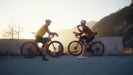 Dos-Ciclistas-Tomando-Un-Descanso-En-Las-Montañas-Al-Atardecer.