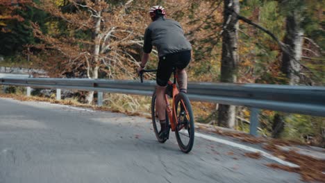 Un-Ciclista-Rodando-Colina-Abajo-Con-Su-Bicicleta-De-Carretera-Con-Casco-Y-Equipo-Completo.