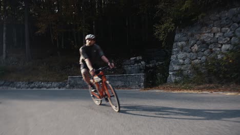 male-bicycle-rider-descending-on-a-mountain-road-with-his-road-bike-in-full-riding-clothes,-helmet