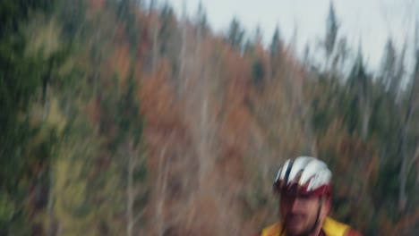 A-male-cyclist-riding-his-road-gravel-bike-up-to-mountain-at-a-high-pace-wearing-full-gear-with-a-helmet