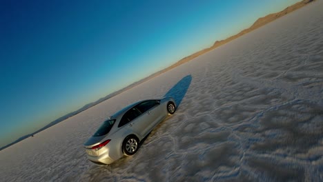 Dron-Aéreo-Fpv-Siguiendo-La-Conducción-De-Un-Automóvil-A-Lo-Largo-De-Las-Salinas-De-Bonneville-En-Utah