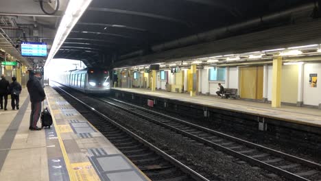 Man-waits-to-board-the-train-at-the-MTR-station-at-Tai-Po-in-New-Provinces,-Hong-Kong