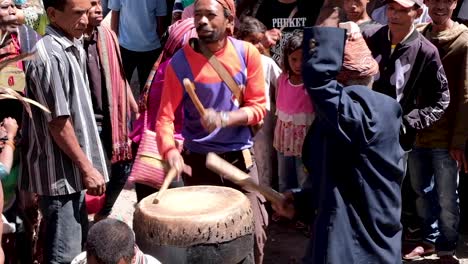 Timorese-men-playing-traditional-drums-with-local-people-from-the-community-dancing-and-watching-during-a-welcome-ceremonial-performance-in-East-Timor,-Southeast-Asia