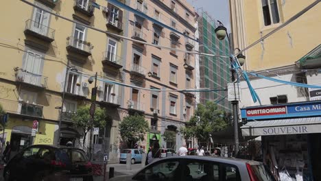 Everyday-busy-scene-in-Italian-street-with-balcony-apartment-block-buildings