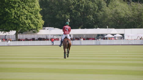 Polospieler-Reitet-Auf-Seinem-Pferd-Mit-In-Der-Luft-Gehaltenem-Schläger