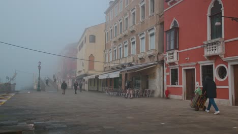 Misty-Calle-Veneciana-A-Primera-Hora-De-La-Mañana,-Los-Lugareños-Viajan-Diariamente