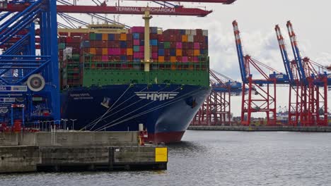 Closeup-shot-of-a-cargo-ship-at-commercial-port-of-Hamburg-with-carriages-on-it-in-Hamburg,-Germany