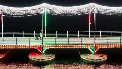 Touristen-Genießen-Funkelnde-Lichter,-Die-Sich-Auf-Den-Karibischen-Gewässern-über-Einer-Brücke-Spiegeln,-Die-Auf-Pontons-In-Curaçao-Schwimmt