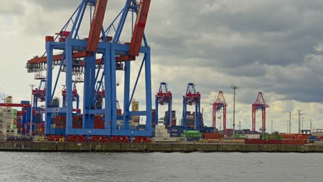 Vista-De-Perfil-De-Un-Puerto-Comercial-De-Hamburgo-Con-Grúas-Trabajando-Durante-Un-Día-Nublado-En-Alemania