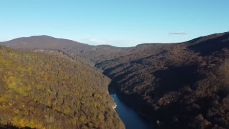 Fluss-Und-Bach-Mit-Kristallklarem-Wasser,-Umgeben-Von-Bergen-Mit-Kiefern-Und-Erdbeerbäumen-Im-Winter