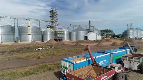 Grano-Vertido-En-Un-Camión-En-Un-Complejo-De-Silos-Durante-Un-Día-Soleado,-Escena-De-La-Industria-Agrícola