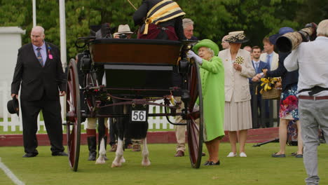 La-Reina-Isabel-Con-Un-Vestido-Verde-Presenta-Un-Trofeo-Al-Conductor-Del-Carruaje-En-La-Exposición-Anual