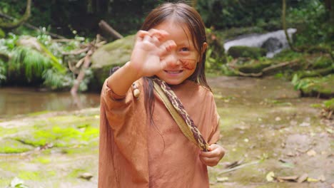 Niña-Indígena-Sonriente-Saludando-En-Pucallpa,-Perú-Con-Fondo-Natural