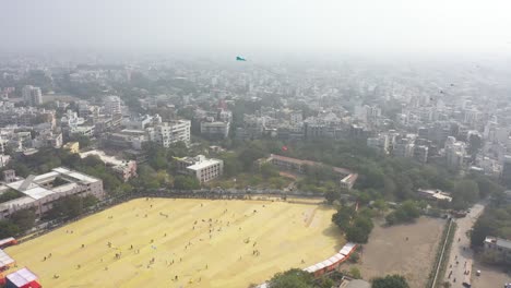 Rajkot-kite-festival-aerial-drone-view-moving-forward-where-lots-of-different-types-of-big-kites-are-flying-in-a-big-field-all-around