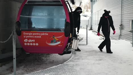 Ein-Paar-Steigt-In-Einem-Skigebiet-In-Sinaia,-Rumänien,-Aus-Der-Gondel