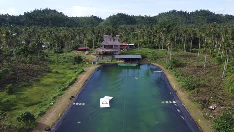 Wakeboarder-surfing-at-wake-park-amid-tropical-nature