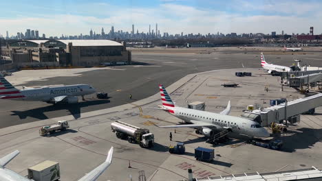 Flugzeuge-An-Gates-Und-Rollen-Am-Flughafen-Laguardia-Mit-Der-Skyline-Von-New-York-In-Der-Ferne